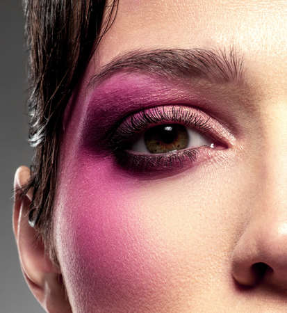 Emotional girl bites her lips. Excited woman. Beautiful sexy girl with bright eye makeup. Sensual young woman is flirting. Sensuality concept.  Glamour fashion model with purple lipstick on her lips.の写真素材