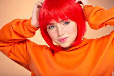 Closeup portrait of an young adult girl with long curly hair.  Photo of a fashion model posing at studio. Pretty young woman with long brown hair looking at camera. Beauty portrait.の写真素材