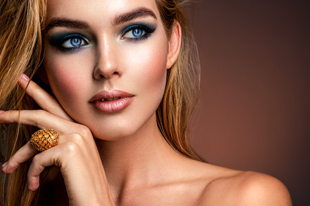 Photo of young woman with style make-up. Portrait of blonde woman with a beautiful face. Closeup face with stylish blue makeup. Fashion model with long hair, studio shot. Fashion concept.の写真素材