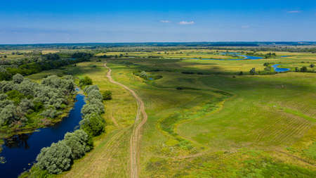 Wide green valley with a small  river . Green meadows. Top view over beauty nature. Aerial  view of a beautiful summer hilly  landscape.の写真素材