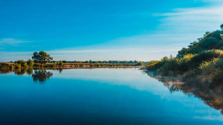 Aerial  view of a beautiful summer  landscape over river while dawn. Top view over river with a smooth water surface reflecting blue sky.の写真素材