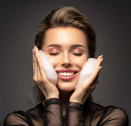 Woman with soap foam on face. Beautiful face of young caucasian woman with perfect healthy skin. ...