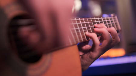 Close-up of a man's hands playing the guitar. The musician plays an acoustic guitar, closeup shot....
