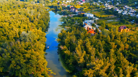 Photo from a drone of a beautiful summer landscape over the river. Beautiful summer landscape with a wide river and green coastline. Aerial photography of the suburban landscape.の写真素材