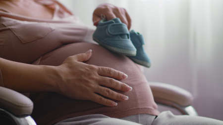 Happy pregnant woman expecting a baby. Expecting mother holding baby in  belly. Pregnant woman...