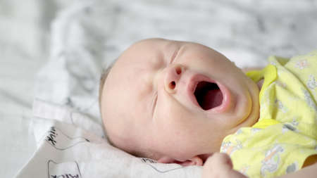 A small baby being active in the morning. Cute infant being energetic on a sunny day. Baby stare. A caucasian baby.の写真素材