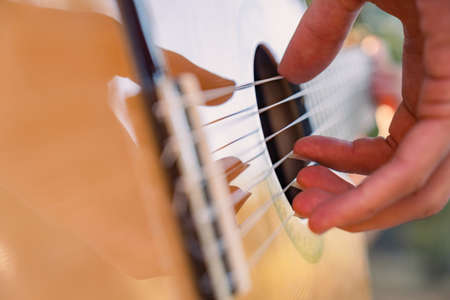 Close-up of the musician's playing hands. The guitarist plays the guitar. Professional guitarist...