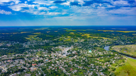 Aerial view of a small city on a beautiful summer day with a green landscape behind it. Picture from...