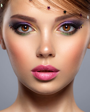Portrait of a beautiful woman with bright makeup. Closeup model face with multicolored eye make-up. Pretty, sexy girl with creative hairstyle. Stylish fashion model with a short hair. Beauty style.の写真素材