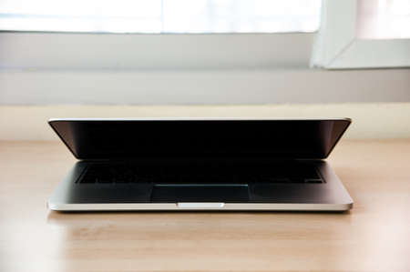 Silver laptop little open, front angleの写真素材