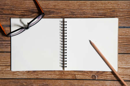 Wood texture mock up with notebook, glasses and pencil. View from above.Create a card.