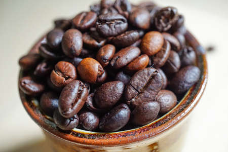 Close of dark roasted coffee bean in antique cup