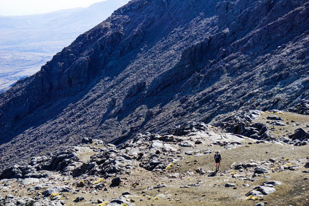 tourist in black dress trailing on rocky way at tongariro national park, taupo, new zealand, with...