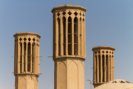Iconic Badgirs (windtowers) in the mud-brick desert city of Yazd, Iran. An ancient rooftop air conditioning system that captures the wind for cooling the houses below.の写真素材