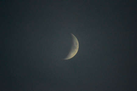 yellow crescent moon with a touch of fog and blue sky with feeling of fantasy or dreams