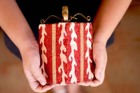 Girl holds a gift in her hands to deliver at an event or gift dayの写真素材