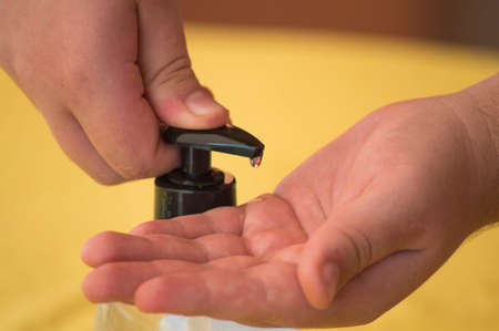 Person who operates the button and cleans their hands with gel or soap for virus covid-19 protection...