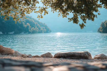 Tranquil lake scene with a view of the mountain peaks and a rocky shoreline.の素材