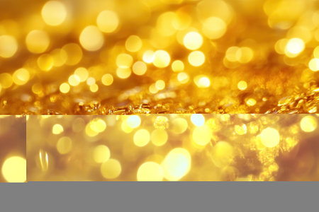 Abstract gold bokeh background with blurred lights and shiny texture.の素材