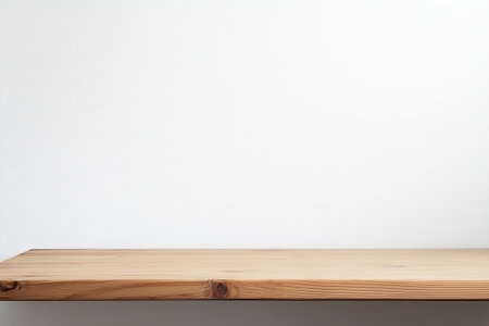 Minimalist wooden shelf against a plain wall.の素材