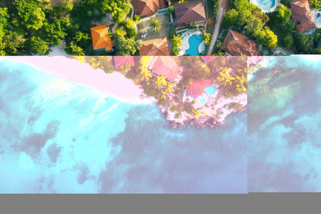 Aerial view of tropical beach houses, turquoise water, and white sand.の素材