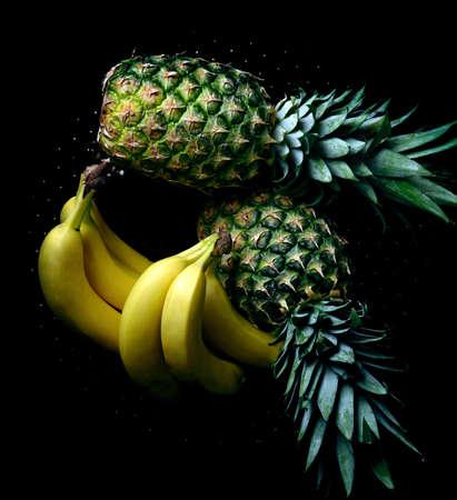 bananas and pineapple on black backgroundの写真素材