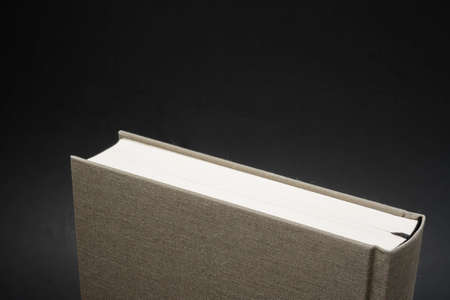 A close-up view of the top portion of a cloth-bound book with permanent black silk bookmark set on a...