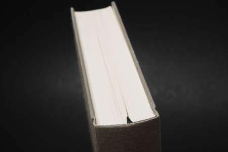 A close-up view of the top portion of a cloth-bound book with permanent black silk bookmark set on a...