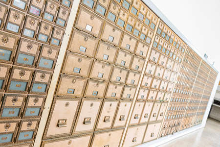 Rows of mid-century modern design post office mailboxes in brass metal.の写真素材
