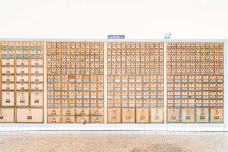Rows of mid-century modern design post office mailboxes in brass metal.の写真素材