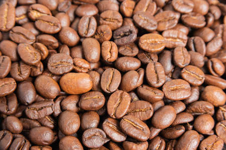 A close-up shot of a spread of roasted coffee beans.の写真素材