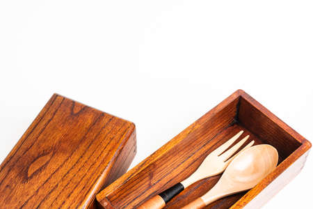 A generic studio product shot of a traditionally crafted Japanese wood bento box on a plain white background.の写真素材