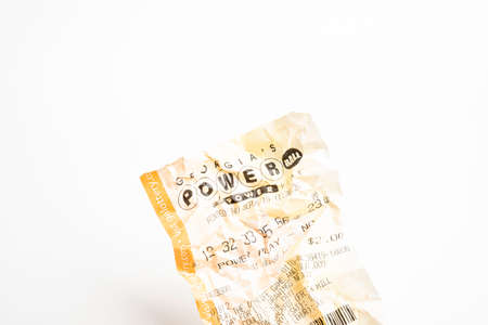 Vidalia, Georgia / USA - September 9, 2019: A close-up studio shot of the crumpled Georgia Powerball yellow lottery printout ticket.のeditorial素材
