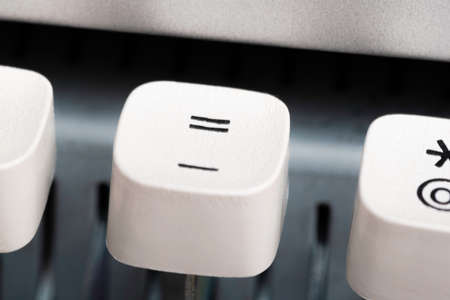 An extreme close-up or macro shot of a plastic keyboard key from a manual typewriter with shallow...