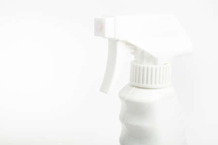 A close-up of the top portion of an all-white liquid spray plastic dispenser bottle set on a plain...