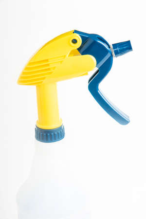 A close-up of the top portion of a professional liquid spray plastic dispenser bottle set on a plain...