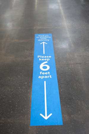 Vidalia, Georgia / USA - May 4, 2020: Walmartâs social distancing policy applied and implemented as floor sign, marker, and reminder.のeditorial素材