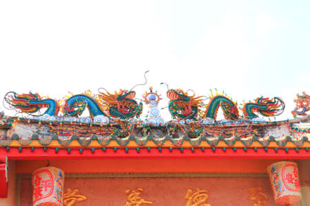 Two dargon scluptures on temple roof.の写真素材