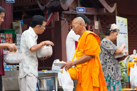 SAKONNAKHON , THAILAND - October 30:unidentified people give food offerings to Buddhist monks on October 30, 2012 in Sakonnakhon, Thailand. Thai traditional, people will make merit making by give food to monkのeditorial素材