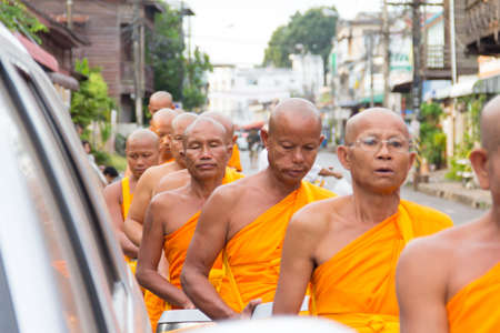 SAKONNAKHON , THAILAND - October 30:unidentified people give food offerings to Buddhist monks on October 30, 2012 in Sakonnakhon, Thailand. Thai traditional, people will make merit making by give food to monkのeditorial素材