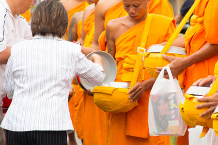 SAKONNAKHON , THAILAND - October 30 unidentified people give food offerings to Buddhist monks on October 30, 2012 in Sakonnakhon, Thailand  Thai traditional, people will make merit making by give food to monkのeditorial素材