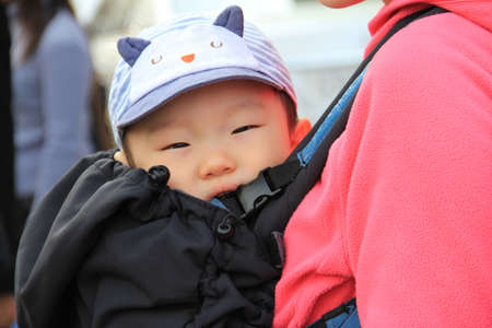 SEOUL,KOREA - APRIL 08 : unidentified  baby in a backpack with my mother  in the knapsack on April 08 ,2011 in Seoul, Korea.のeditorial素材