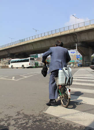 SEOUL,KOREA- APRIL 08:unidentified people  on a bicycle to cross the road  on April 08,2011 in Seoul, Korea.のeditorial素材