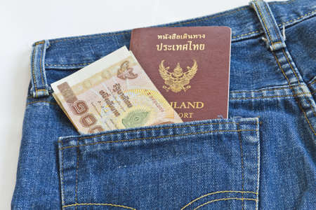 Thailand passport and Thai money on on a jeans pocket, closeupの写真素材