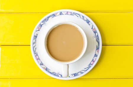 Cup of coffee over the yellow backgroundの写真素材