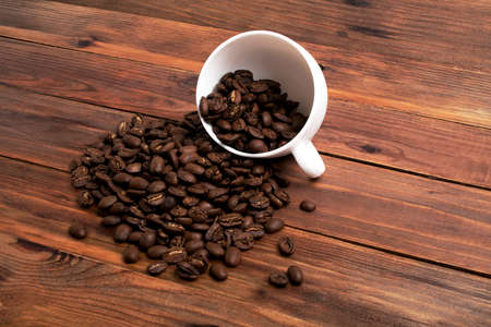 Coffee beans and cup on wood background