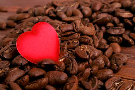 Coffee beans and red heart on wooden backgroundの写真素材