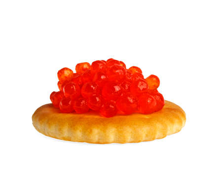 Red caviar on a round cracker isolated on white backgroundの写真素材