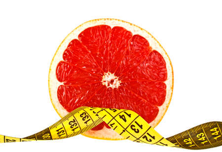 Diet concept: slice of grapefruit and measuring tape on white backgroundの写真素材