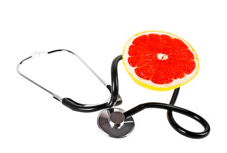 Concept for healthcare - slice of grapefruit and stethoscope on a white backgroundの写真素材